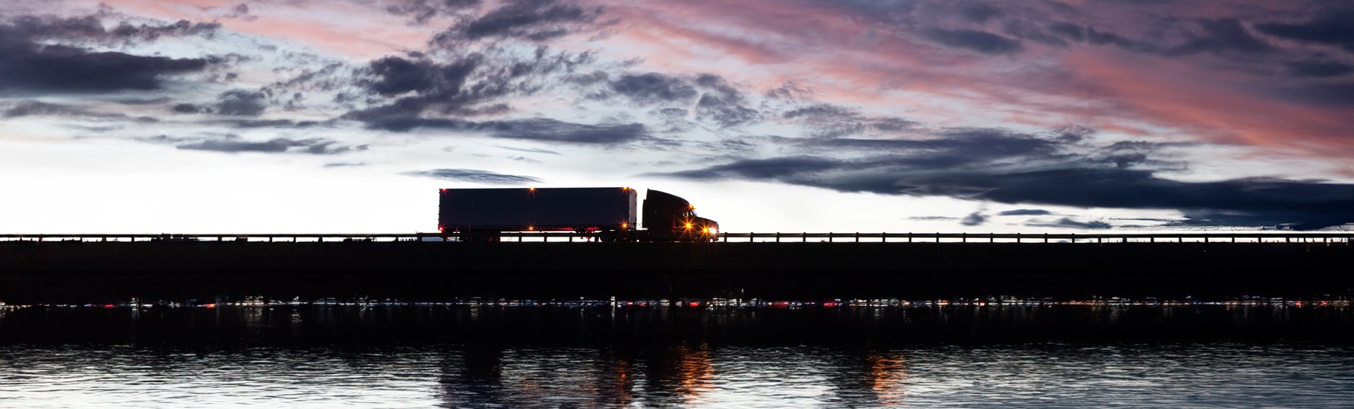silhouette-of-a-commercial-truck-driving-on-a-high-2023-11-27-04-49-05-utc